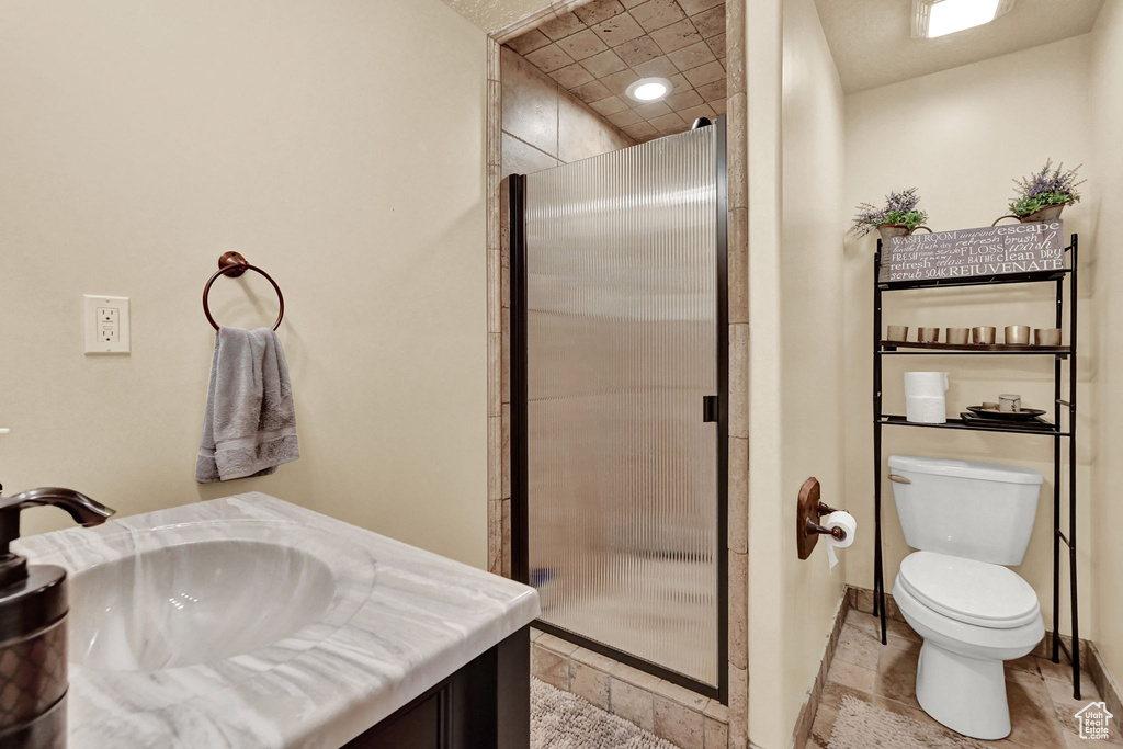 Bathroom with an enclosed shower, toilet, and vanity