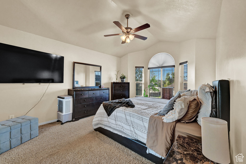 Carpeted bedroom with lofted ceiling and ceiling fan