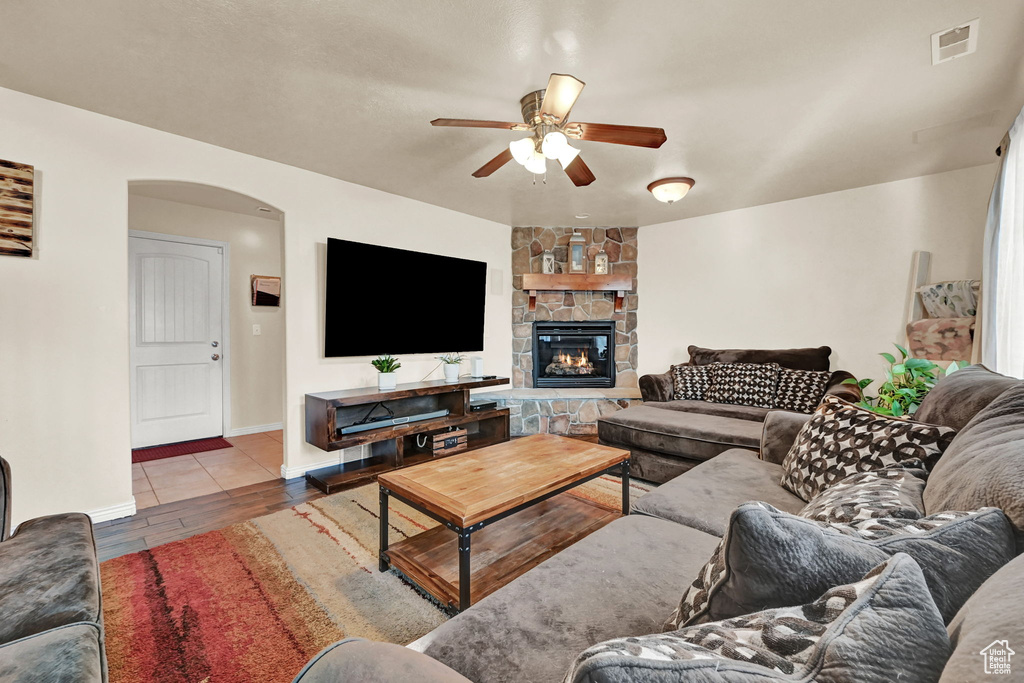 Living room featuring a fireplace and ceiling fan