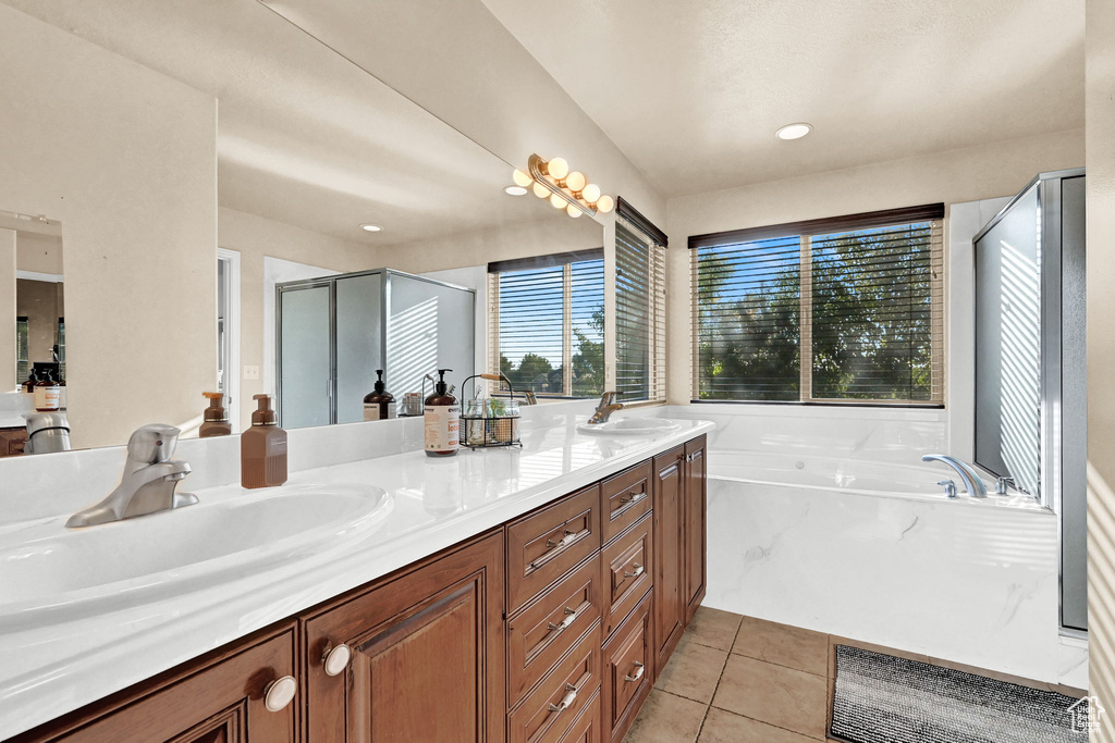 Bathroom with vanity, tile patterned floors, and plus walk in shower