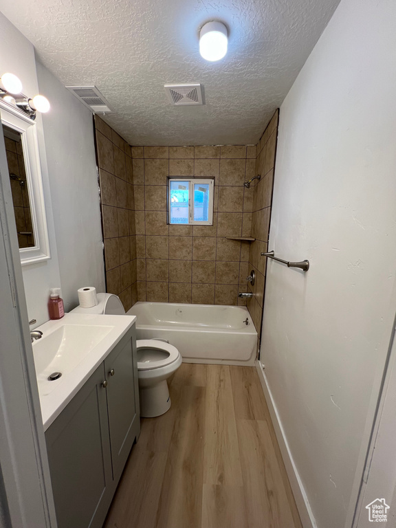 Full bathroom featuring vanity, toilet, hardwood / wood-style floors, and tiled shower / bath