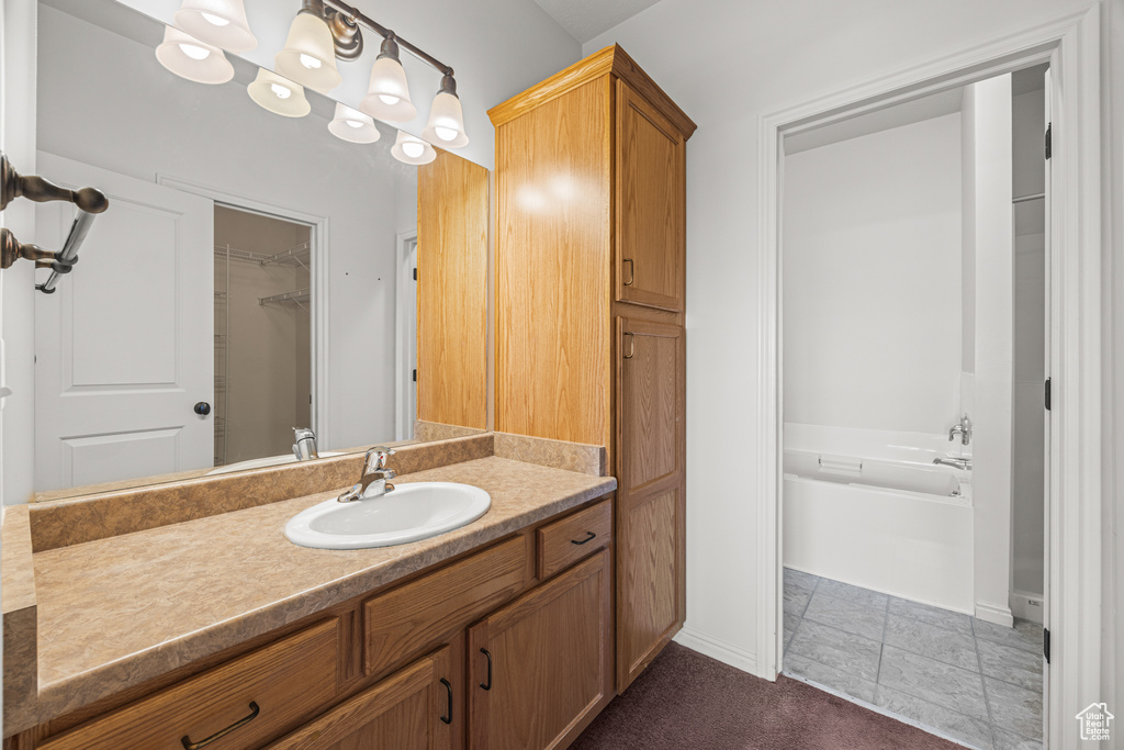 Bathroom featuring vanity, tile patterned floors, and a washtub