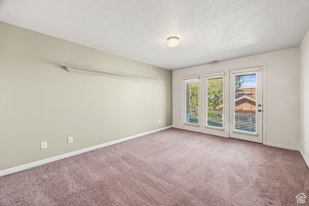 Carpeted empty room with a textured ceiling