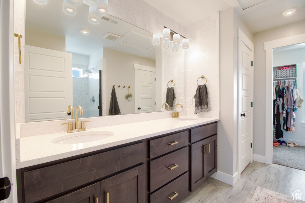 Bathroom featuring wood-type flooring, a shower with door, and vanity