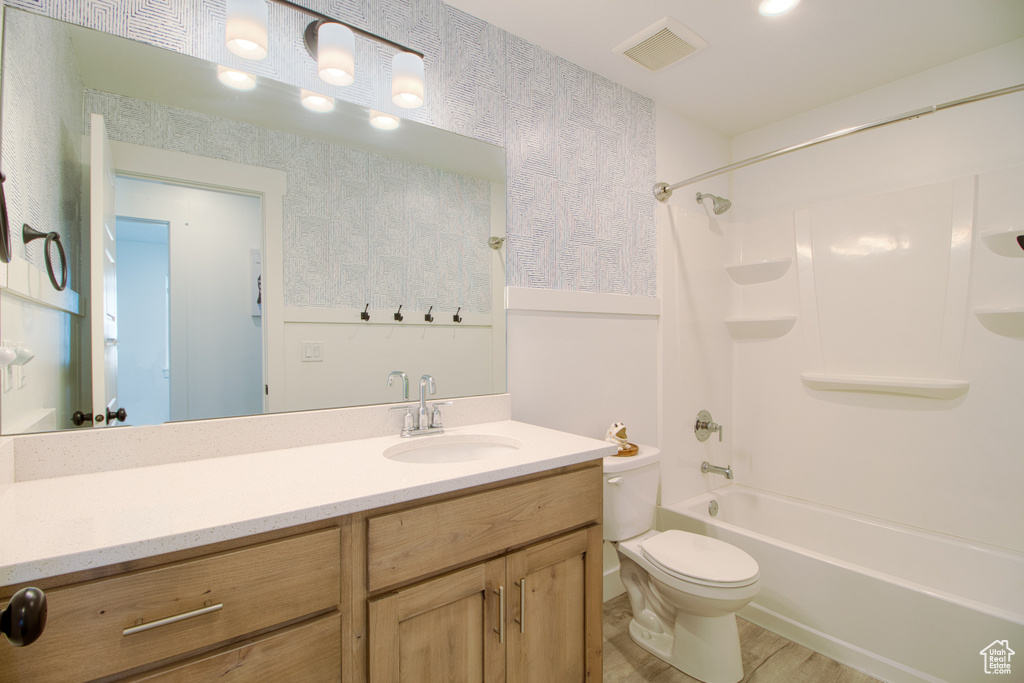 Full bathroom featuring toilet, tub / shower combination, and vanity