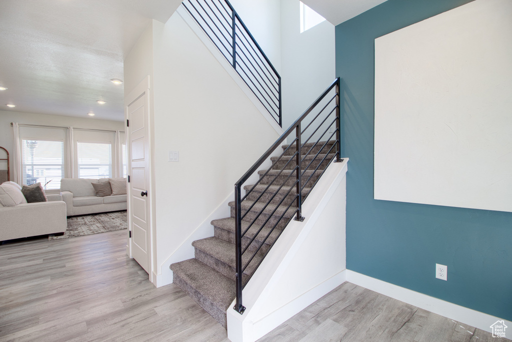 Stairs featuring hardwood / wood-style flooring