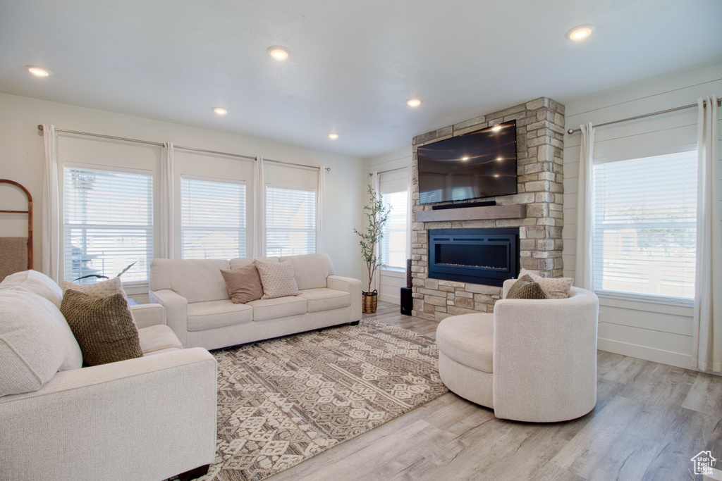 Living room with a fireplace, plenty of natural light, and hardwood / wood-style floors