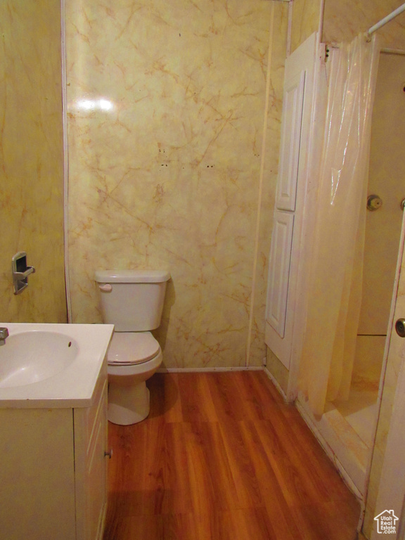 Bathroom with vanity, toilet, a shower with shower curtain, and hardwood / wood-style floors