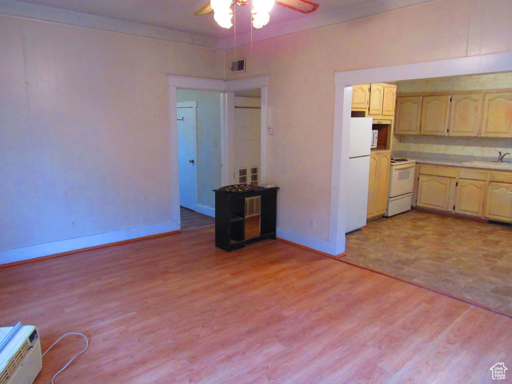 Kitchen featuring white appliances, light hardwood / wood-style flooring, sink, and ceiling fan