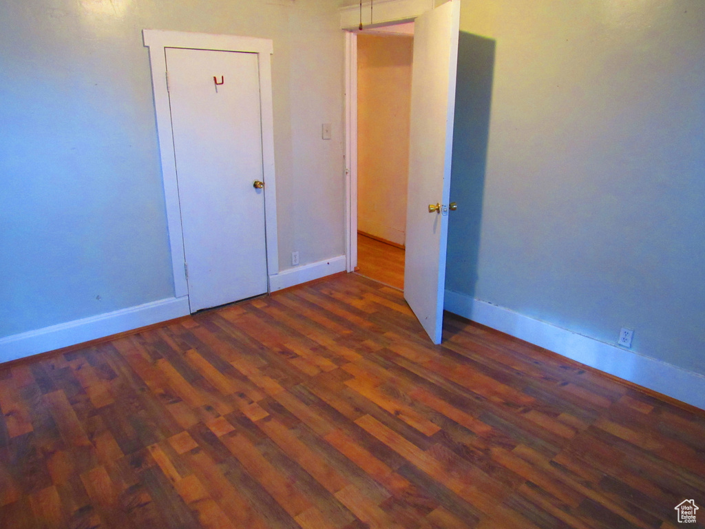 Unfurnished bedroom featuring dark hardwood / wood-style floors