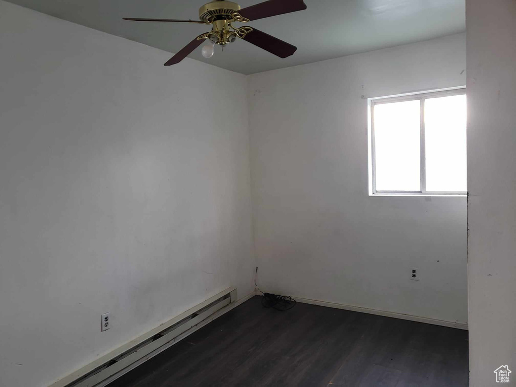 Spare room with a baseboard heating unit, dark hardwood / wood-style flooring, and ceiling fan