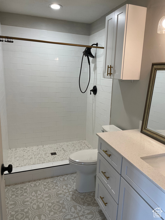 Bathroom with a tile shower, toilet, and vanity