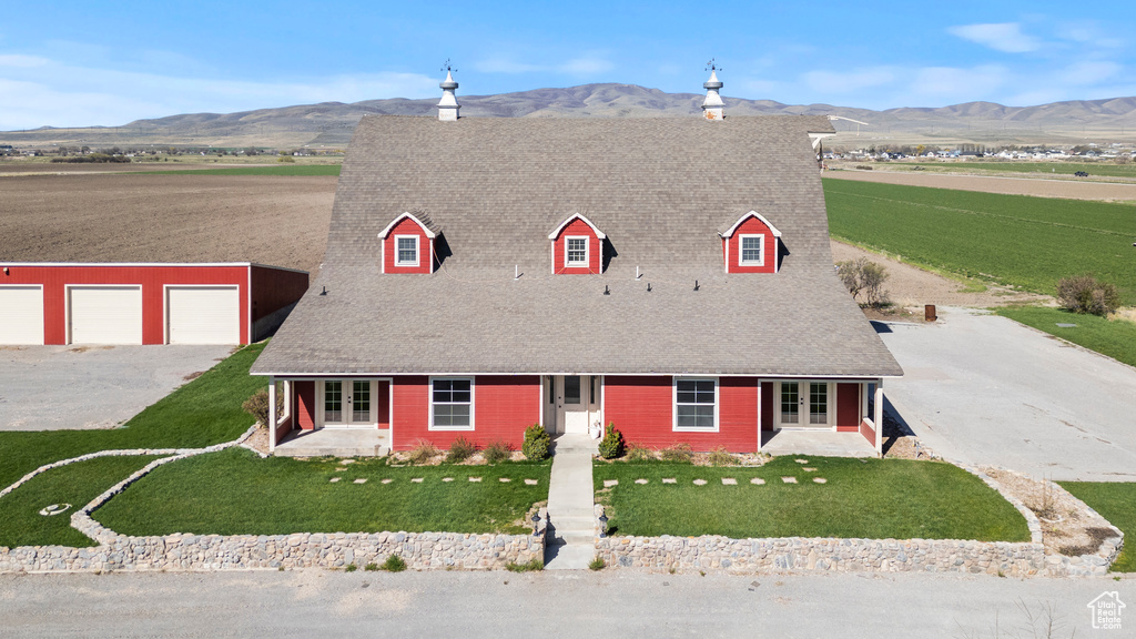 Cape cod-style house featuring french doors, a mountain view, a front yard, and driveway
