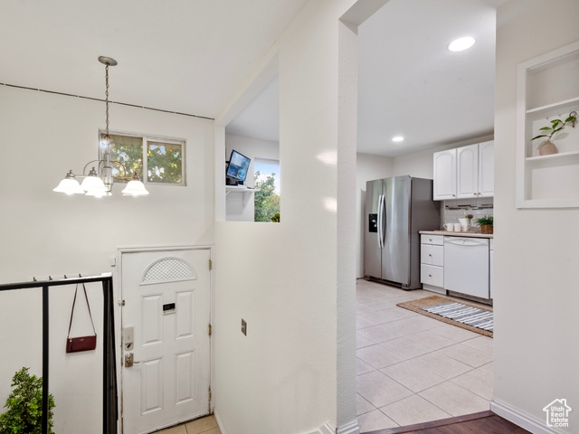 Foyer entrance featuring light tile patterned flooring and a chandelier