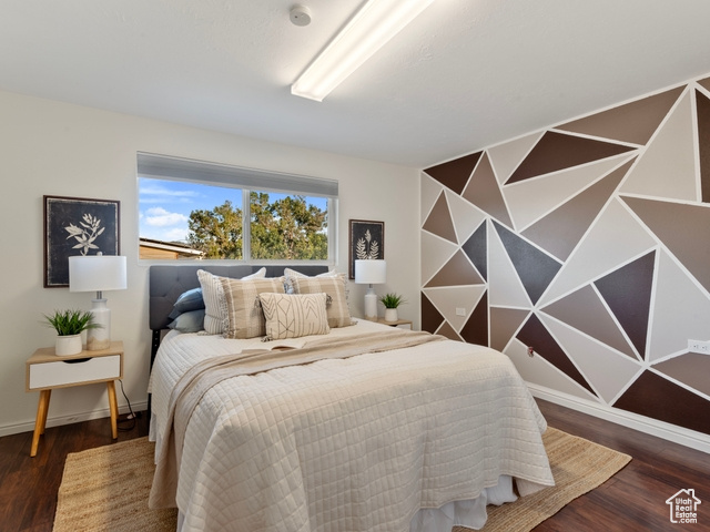 Bedroom with dark hardwood / wood-style floors