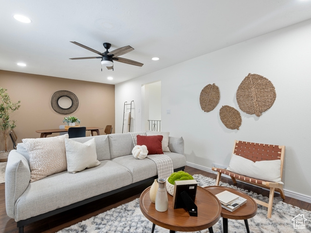 Living room featuring dark wood-type flooring and ceiling fan