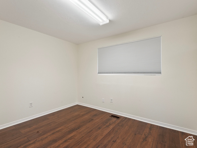 Empty room with hardwood / wood-style floors