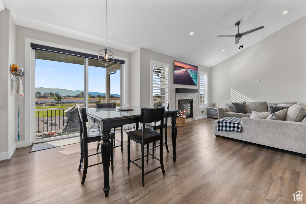 Dining area with ceiling fan, hardwood / wood-style floors, and vaulted ceiling