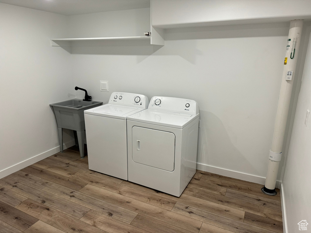 Laundry area with light wood-type flooring and washer and dryer