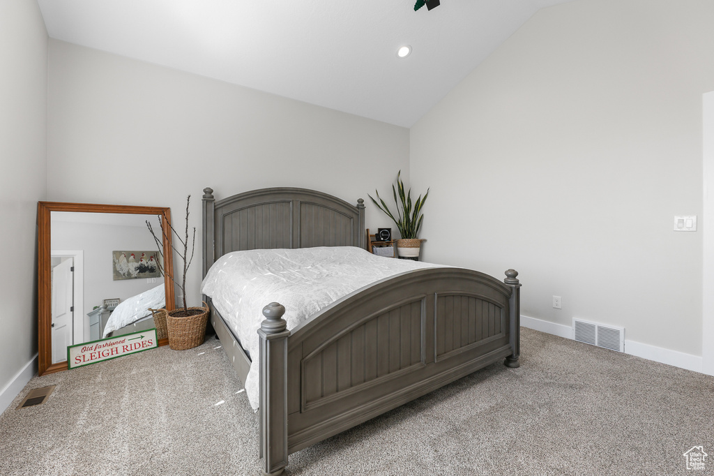 Carpeted bedroom featuring lofted ceiling