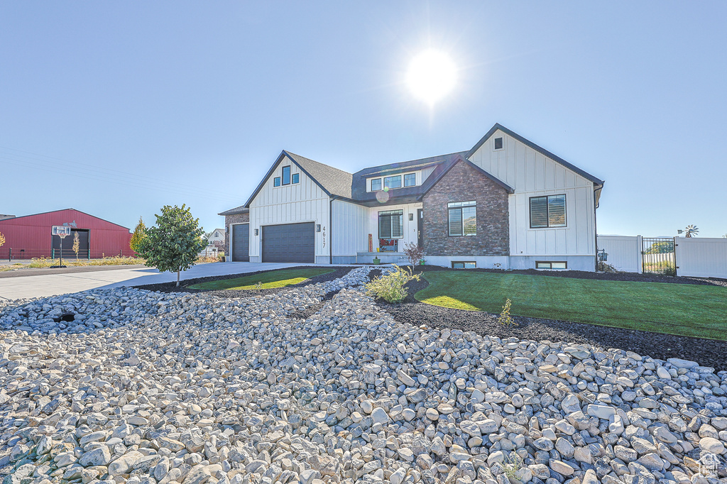 Modern farmhouse with a garage and a front lawn