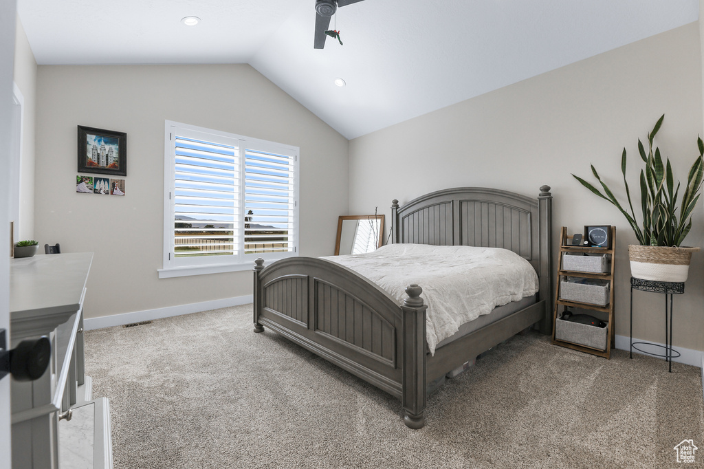 Carpeted bedroom with vaulted ceiling and ceiling fan