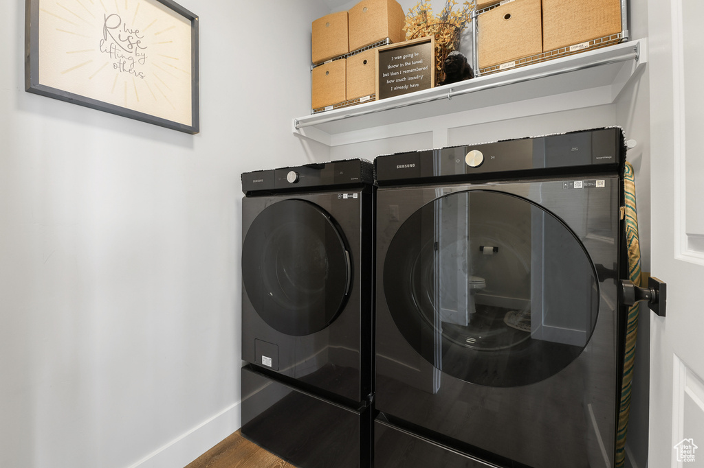 Washroom featuring washing machine and clothes dryer and hardwood / wood-style floors