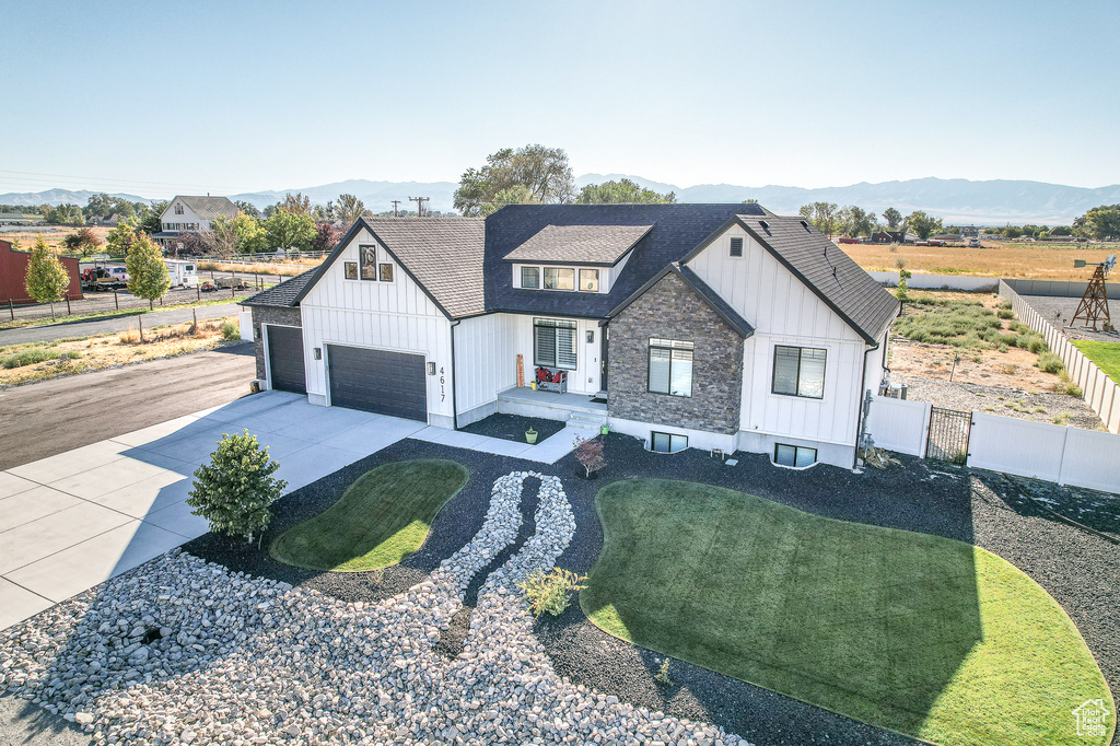 Modern inspired farmhouse with a mountain view, a garage, and a front yard