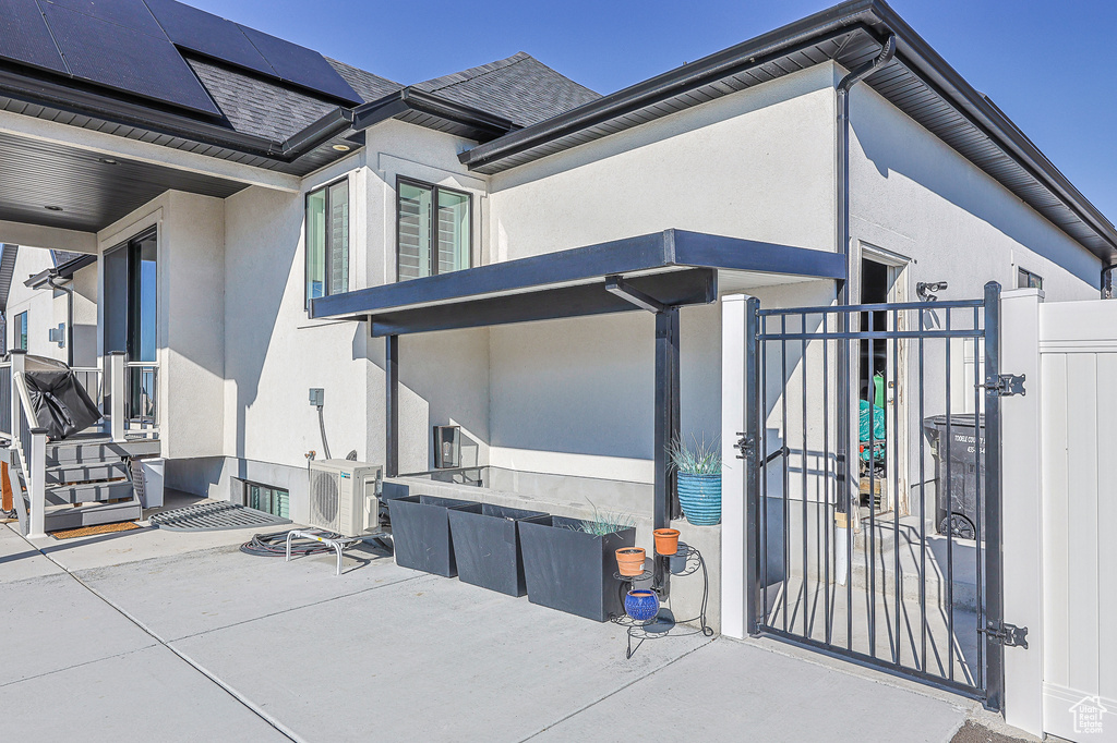 View of home\'s exterior with ac unit, solar panels, and a patio area