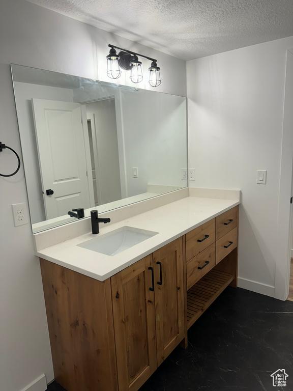 Bathroom with vanity and a textured ceiling