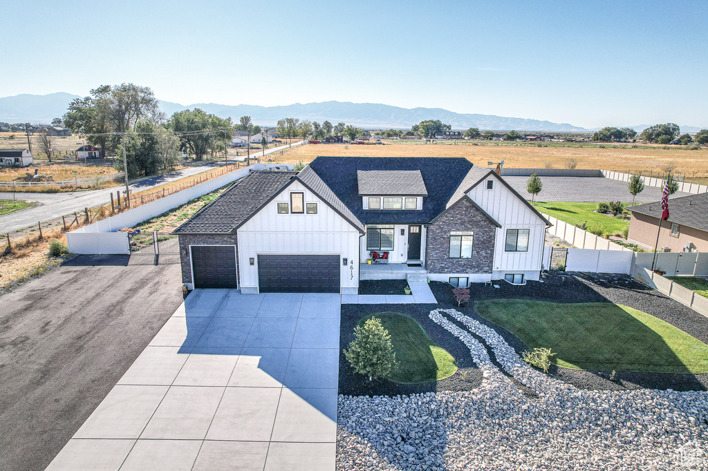 Modern farmhouse style home with a mountain view, a front yard, and a garage