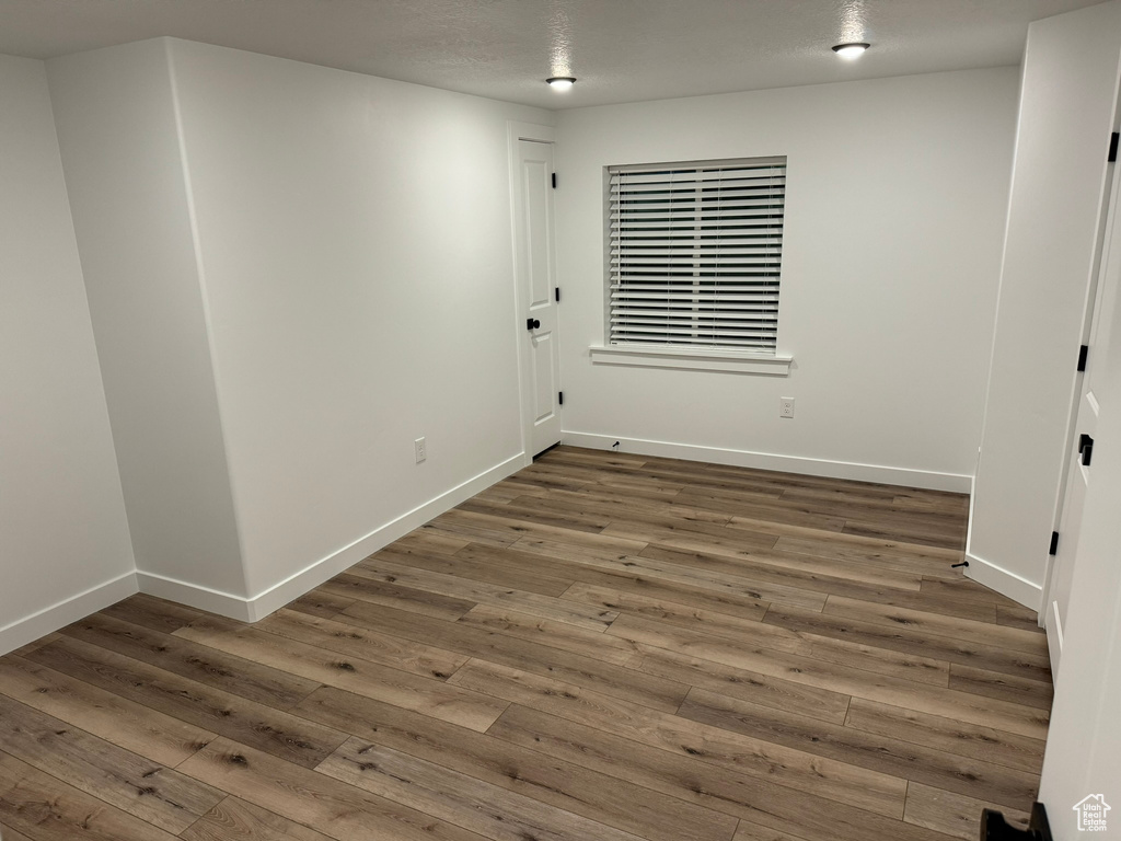 Spare room featuring a textured ceiling and dark hardwood / wood-style floors