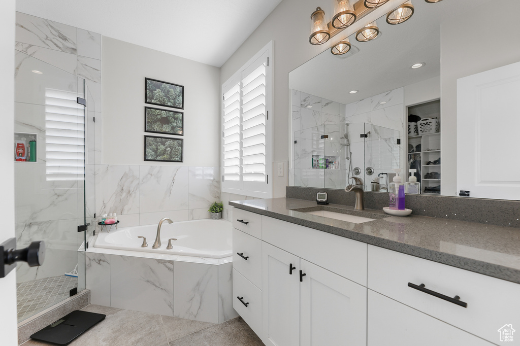 Bathroom featuring shower with separate bathtub and vanity