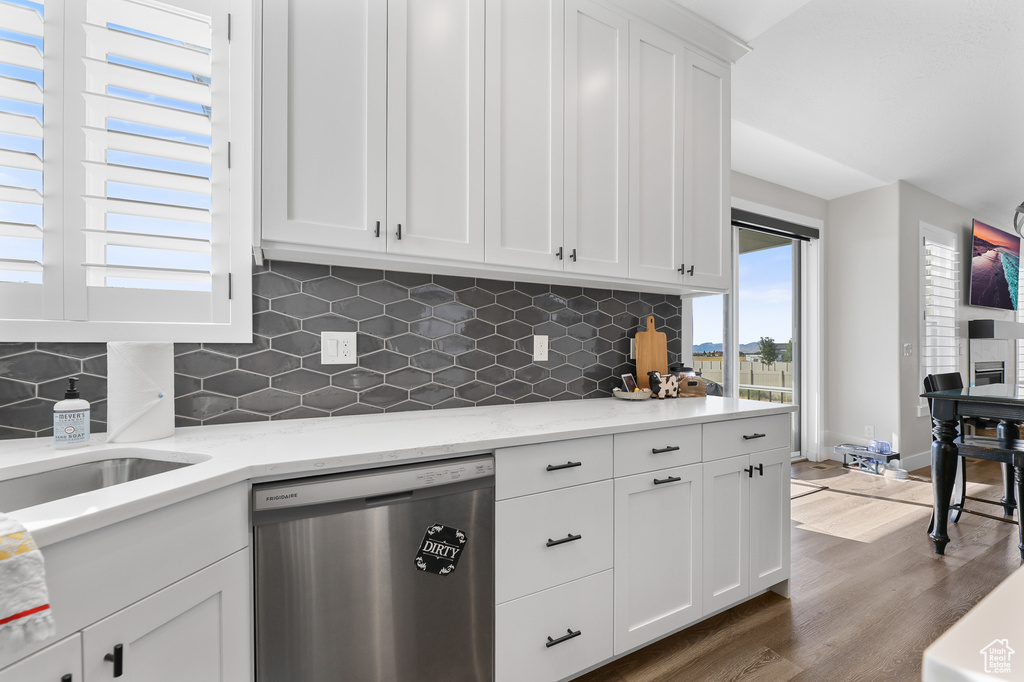 Kitchen featuring hardwood / wood-style floors, dishwasher, white cabinetry, and a healthy amount of sunlight