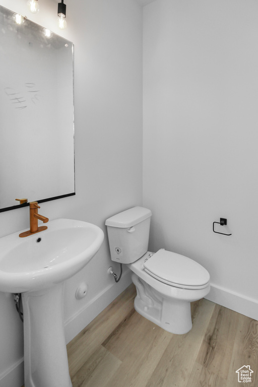 Bathroom with toilet and hardwood / wood-style flooring