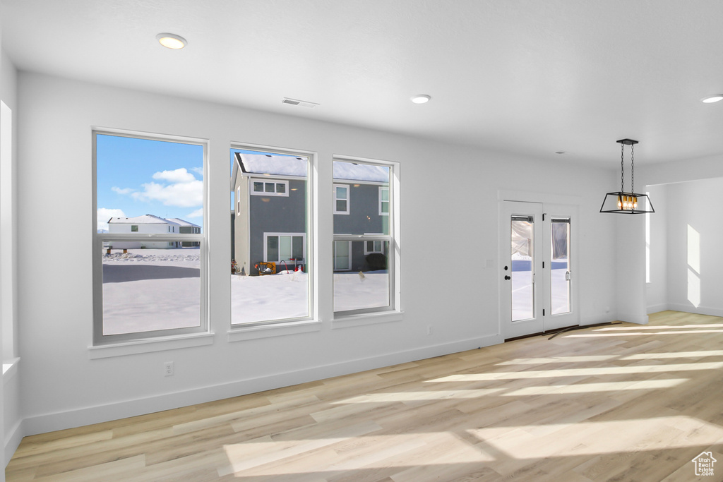 Spare room featuring a healthy amount of sunlight and light hardwood / wood-style floors