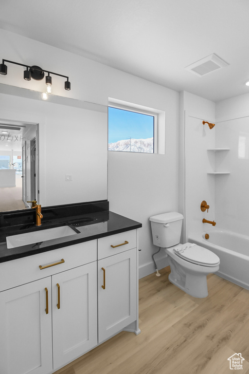 Full bathroom featuring vanity, toilet, hardwood / wood-style flooring, and shower / bathtub combination