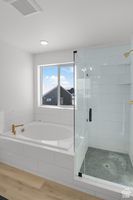 Bathroom with plus walk in shower and hardwood / wood-style flooring