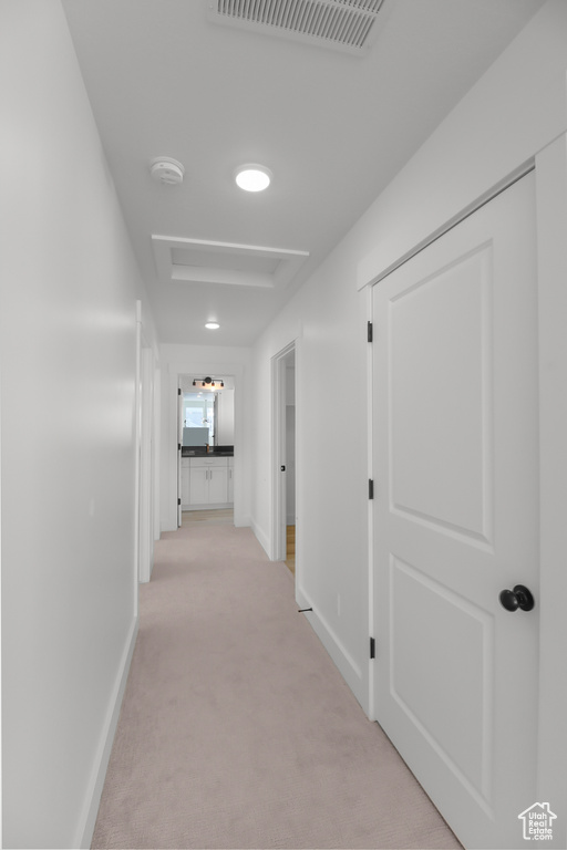 Corridor featuring light colored carpet