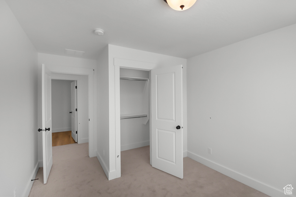 Unfurnished bedroom with a closet and light colored carpet