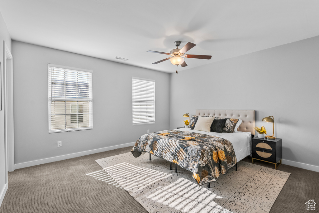 Carpeted bedroom featuring ceiling fan