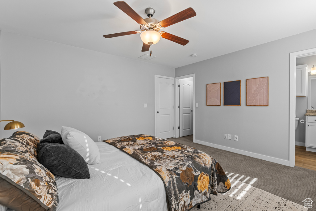 Bedroom featuring ceiling fan, carpet, and ensuite bath