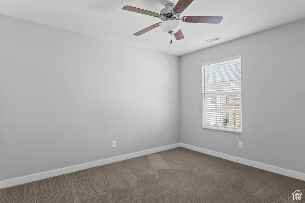 Empty room with ceiling fan and carpet floors