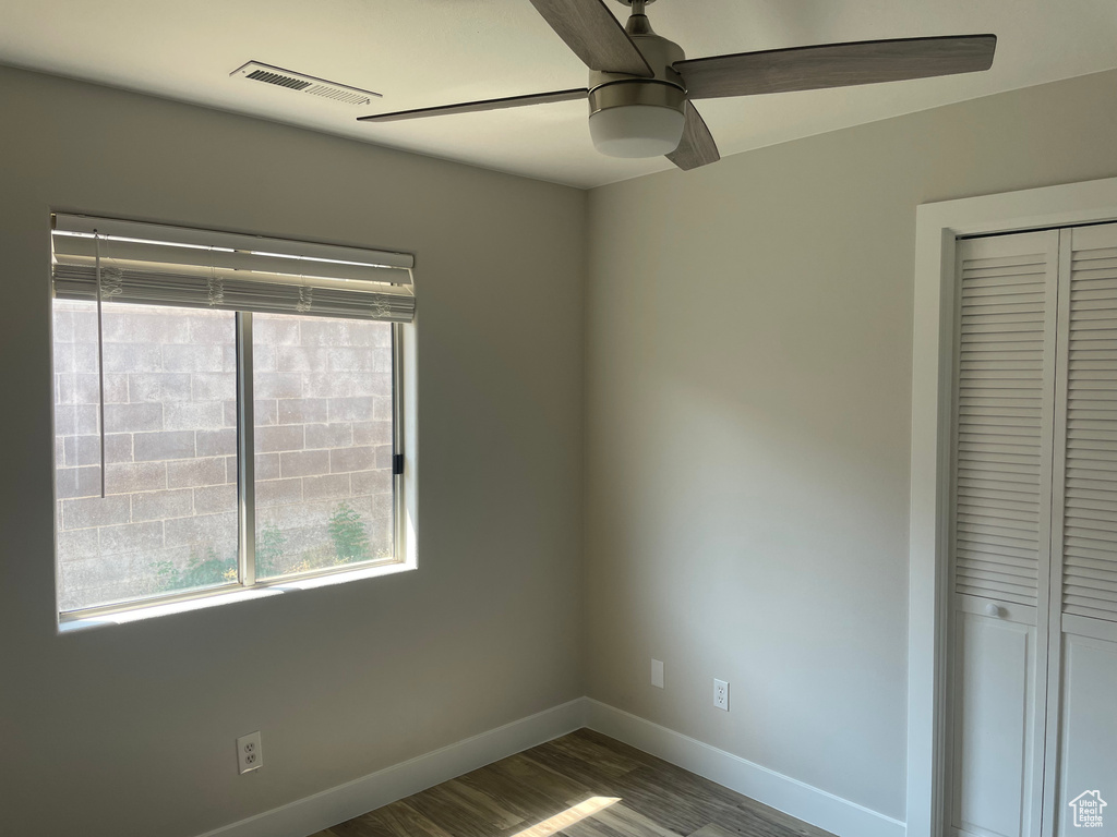 Unfurnished bedroom with ceiling fan, a closet, and wood-type flooring