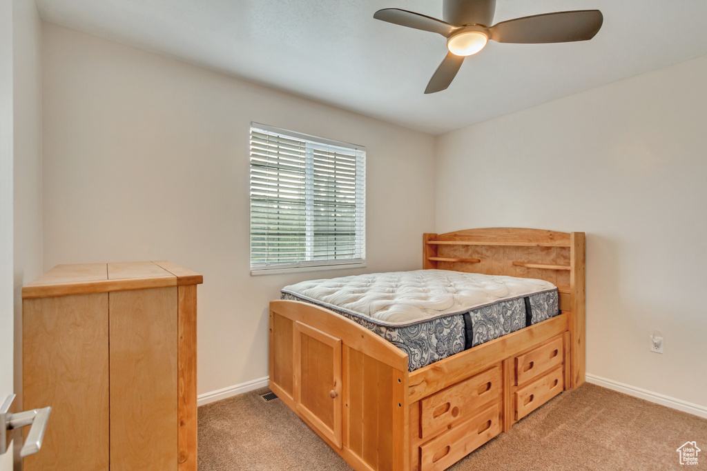 Carpeted bedroom with ceiling fan