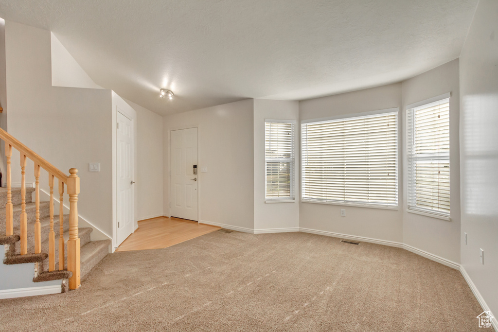 Foyer entrance with light colored carpet