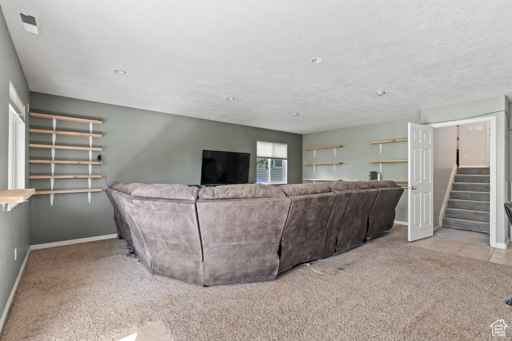 Carpeted living room featuring a textured ceiling