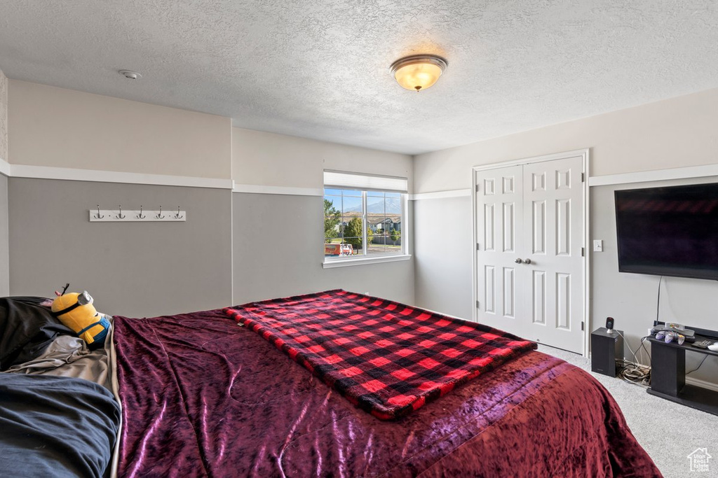 Bedroom with a textured ceiling and carpet