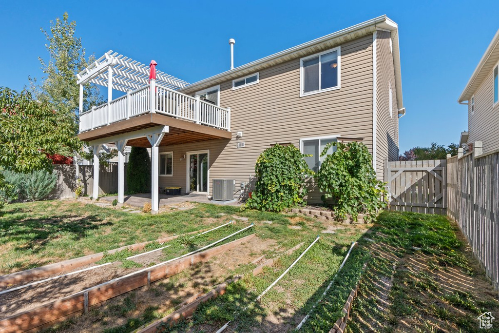 Rear view of property featuring a yard, a deck, a patio, and central AC