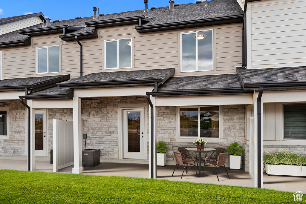 Rear view of property with a patio area, a yard, and central air condition unit